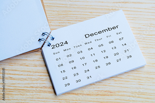 Top view of December 2024 calendar on wooden background. Calendar month of year 2024 concept