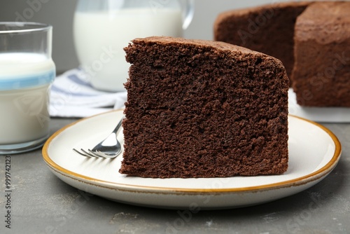 Piece of tasty chocolate sponge cake served on grey table, closeup