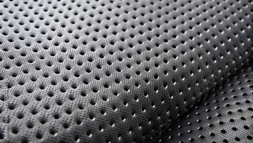 Perforated neoprene texture with small evenly spaced holes on a black surface for innovative designs