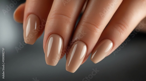 Closeup of a hand with nude-colored, almond-shaped nails.