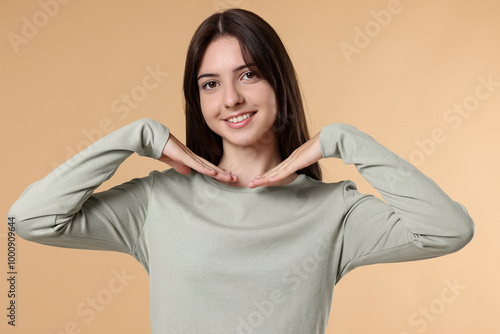 Portrait of cute teenage girl on beige background