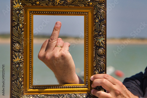 the finger of a man with a golden frame makes the gesture with the middle finger raised, expressing annoyance and discomfort and dissatisfaction. Concept expressions and anger.