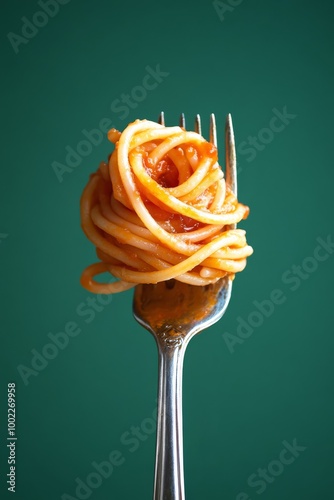 A fork with a twirl of spaghetti against a green background. Perfect for food blogs, recipe websites, and culinary magazines.