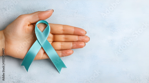 Teal ribbon on womans hand symbolizing awareness for ovarian cancer and PCOS. Concept Cancer Awareness, PCOS Awareness, Teal Ribbon, Health Advocacy