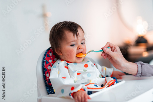 A little baby girl dislikes her healthy meal but in spite of that she is eating somehow 