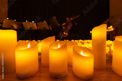 blurred symphonic orchestra on stage with lots of candles