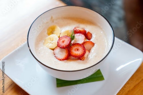 delicious and organic bowl of oatmeal with colorful strawberries and bananas at healthy restaurant in south american city with fresh fruit