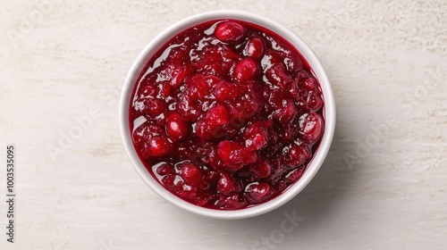 Bowl of cranberry sauce on a light textured background.