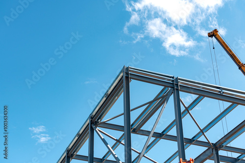 Construction progress on modern steel structure under bright blue sky in mid-afternoon light