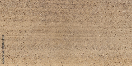 view from above on texture of dry muddy road with tractor tire tracks in countryside