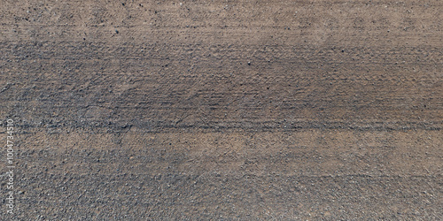 view from above on texture of dry muddy road with tractor tire tracks in countryside