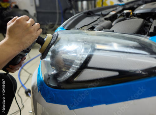 Person using a machine to polish automotive lighting on a car headlight