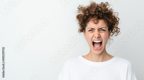 Angry Woman Portrait: Frustration and outrage captured in a close-up shot of a young woman with curly hair, her mouth wide open in a scream. The intensity of her expression conveys raw emotion.