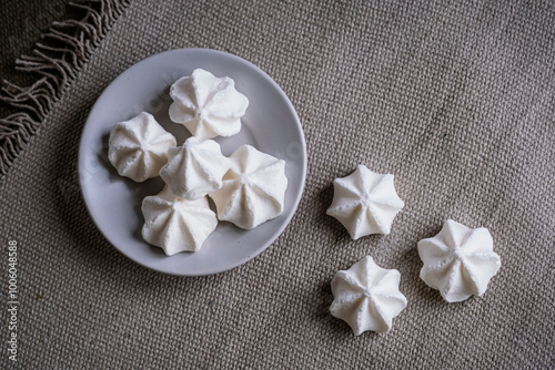 Petites meringues sucrées fait-maison en forme de rocher dans une assiette posée sur la table