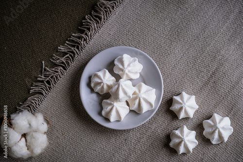 Petites meringues sucrées fait-maison en forme de rocher dans une assiette posée sur la table