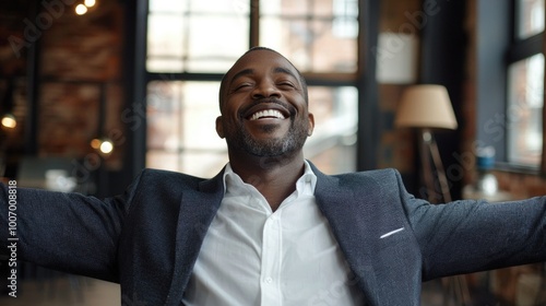 A middle-aged African American businessman smiles happily in his stylish office