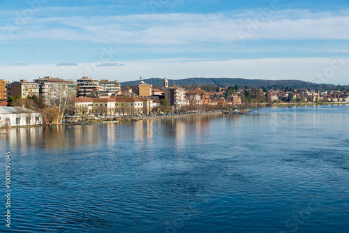 Big Italian river. Ticino river in Sesto Calende at the exit from lake Maggiore. City of Sesto Calende with the promenade along the river