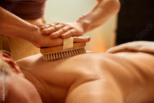 Dry brush massage. Close-up of woman having dry brush massage at spa