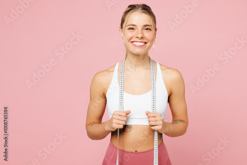 Young fun smiling happy woman wear white top casual clothes hold measure tape on neck look camera isolated on plain pastel pink background. Proper nutrition healthy fast food unhealthy choice concept.