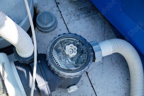 Close-up of a pool filtration system in a backyard garden.