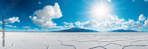 A large, empty desert with a bright sun shining down on it. The sky is mostly clear, with only a few clouds scattered throughout. The scene is peaceful and serene