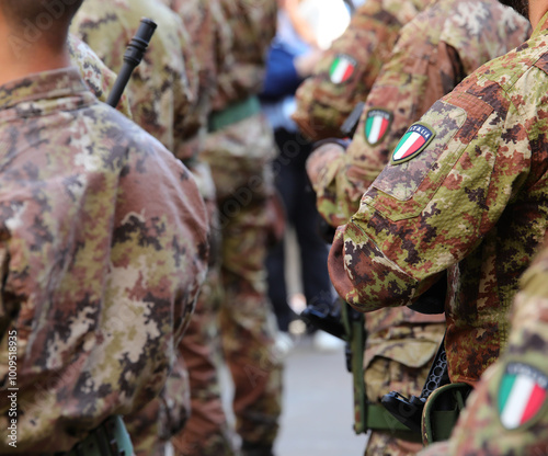 soldiers in the Italian army in camouflage uniform with the flag coat of arms