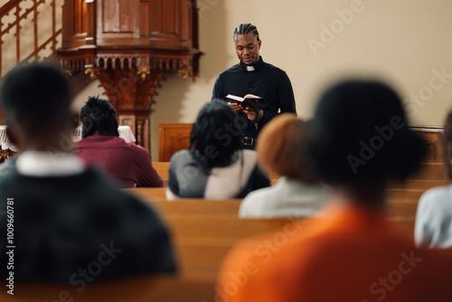 Young priest reading from the bible to his congregation