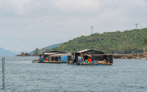 Vietnamese houses on the water, fish farms and fishing boats on the background of tropical islands