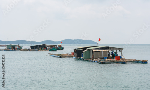 Vietnamese houses on the water, fish farms and fishing boats on the background of tropical islands