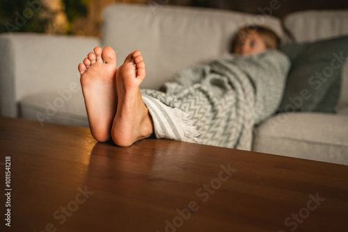 Relax young girl wrapped in blanket resting comfortably on couch