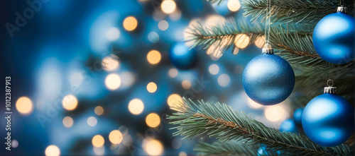 Blue Christmas ornaments in vibrant blue and silver, hanging tree branch with warm bokeh lights , glowing softly in the evening light.