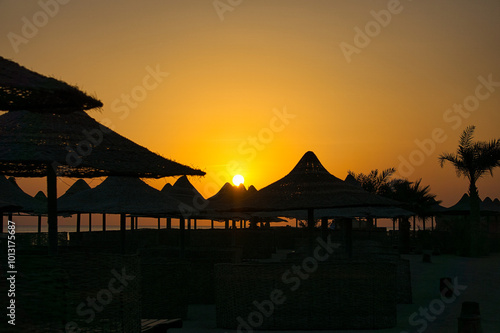 Close-up of beach umbrellas - beautiful setting sun in the background. Beach on the Red Sea, Egypt