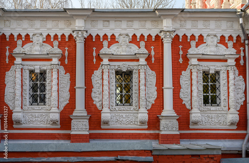 Windows with stucco platbands and bas-reliefs against the background of the red brickwork of the Cathedral of the Most Holy Theotokos, built in 1719 in Nizhny Novgorod, Russia