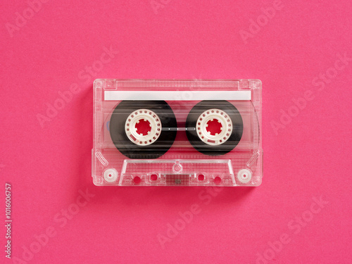 Audio cassette tape lying on pink background