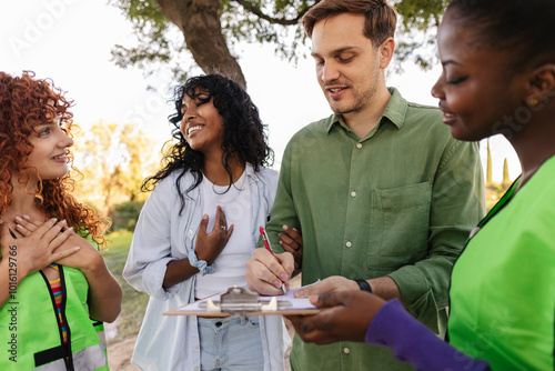 A diverse group of volunteers collecting signatures for a community petition, engaging with people outdoors with smiles.