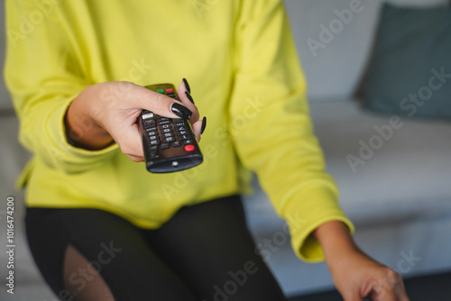 close up of woman hold remote control and pop corn enjoy the movie