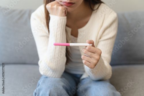 Close-up young woman checking on the pregnancy test and the result is positive.