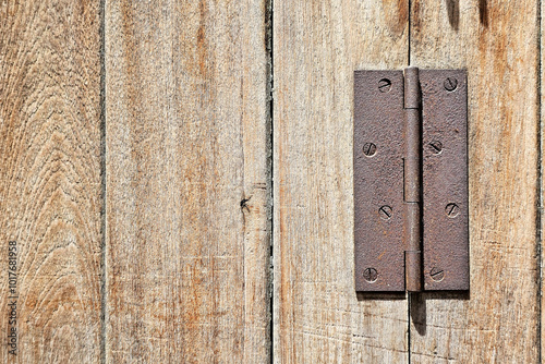 Rusty Old Hinge on Wooden Background.