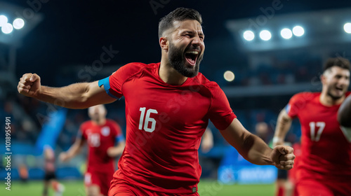 Soccer player in red shirt celebrating a goal or win. A player in a red shirt joyfully celebrates after scoring a critical goal during an intense soccer match under stadium lights.