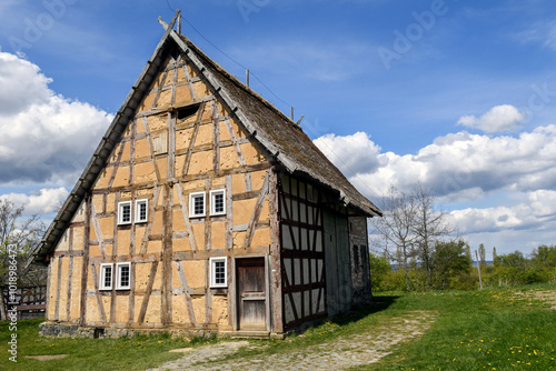 A traditional German half timbered house stands under a blue sky,