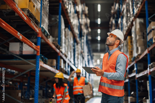 Warehouse manager using digital tablet checking inventory