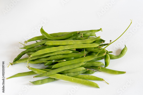 Freshly harvested organic pile of climbing French bean, Blue Lake variety, on white background. Juicy and round pods.