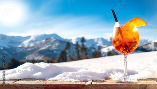 Im Vordergrund ein Aperol Spritz, im Hintergrund ein Skigebiet im Winter traumhaftes Bergpanorama 