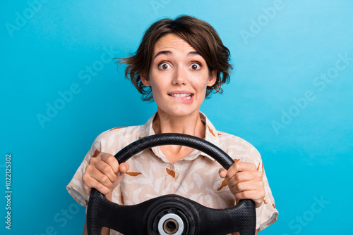 Portrait of pretty person biting lips arms hold wheel driving exam test isolated on blue color background