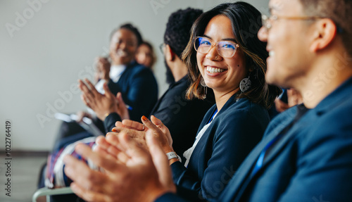 Diverse colleagues clapping and smiling during business meeting