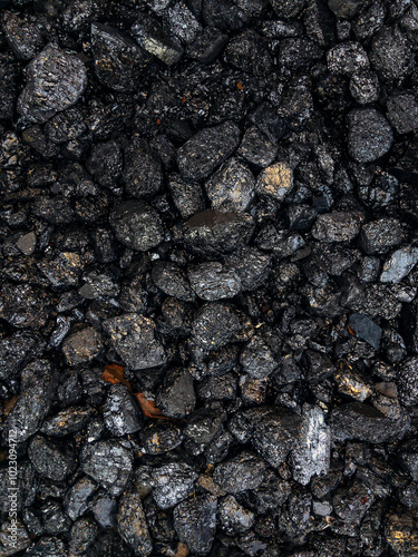 Coal. The dark texture is black. Background image of anthracite coal. The surface of natural black coal. A grade of high-quality metallurgical coal anthracite. Black background. Vertical image.