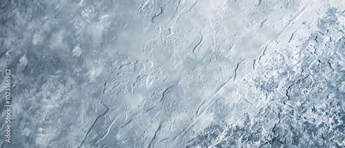 An icy, textured surface reveals the raw beauty of frozen patterns and cracks, invoking a sense of natural artistry.