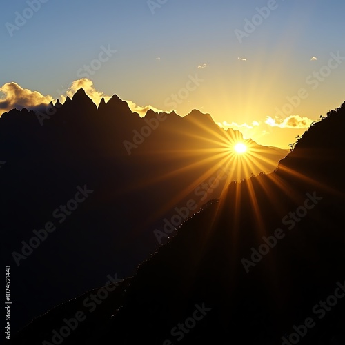 Majestic mountain range silhouette with a rising sun peeking over the peaks