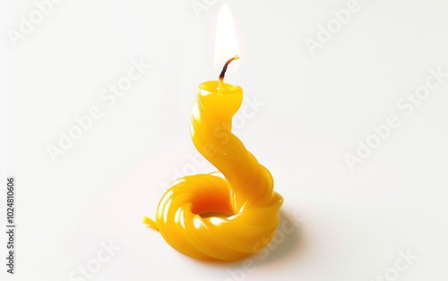 Twisted yellow candle with flame burning, against a plain white background. Concept of light, spirituality, and relaxation.