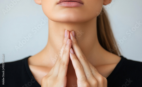 A woman self-examines her thyroid, which may be affected by conditions like goiter, hyperthyroidism, hypothyroidism, tumors, or cancer